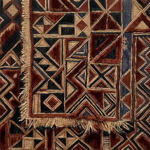 フリンジ付きの黒とクリーム色の幾何学模様のクバ布を再現した油彩画